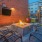 Firepit with lounge chairs all around near a mounted TV at Trailside at Reedy Point Apartments