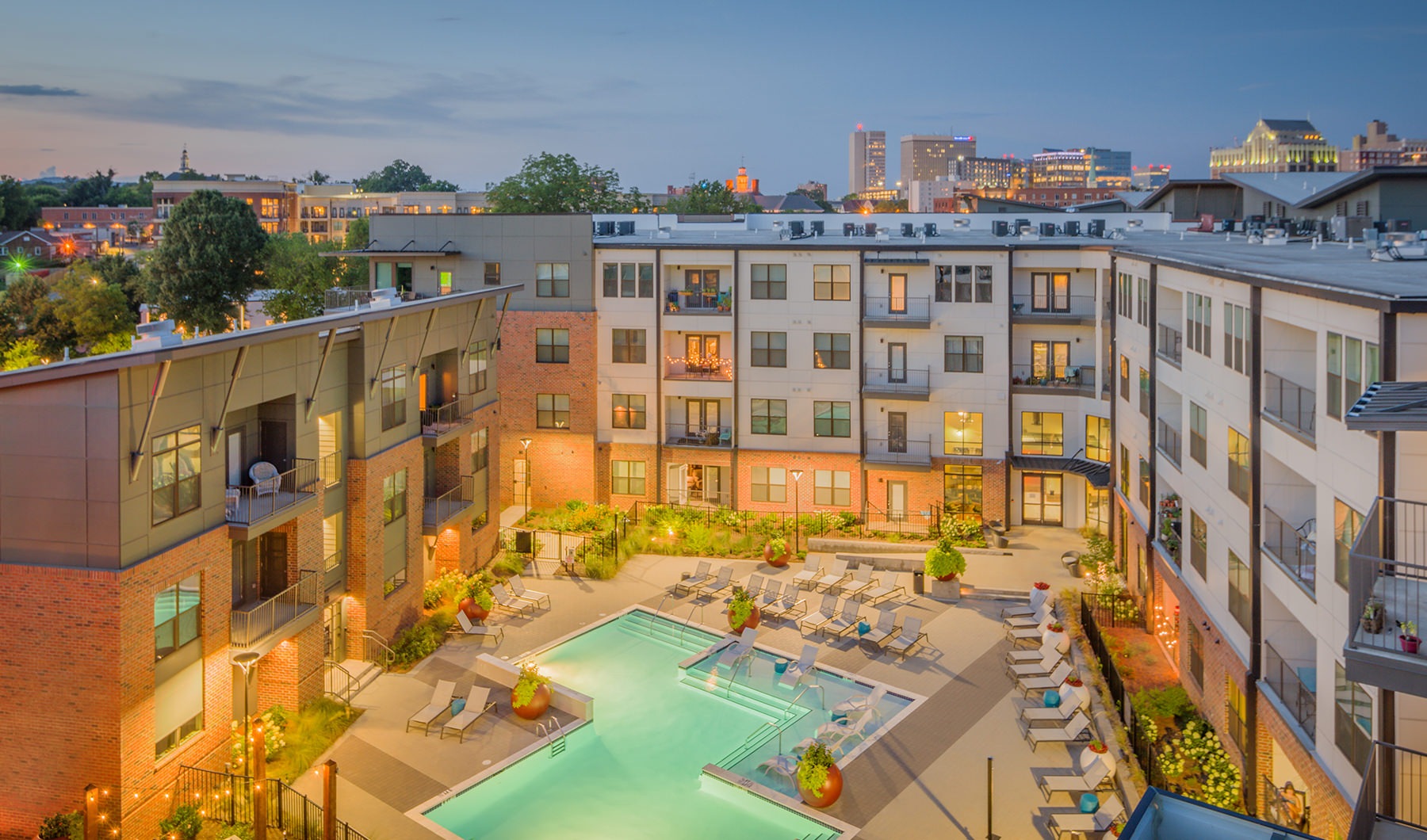 Aerial view of pool and Trailside at Reedy Point's building at dusk 